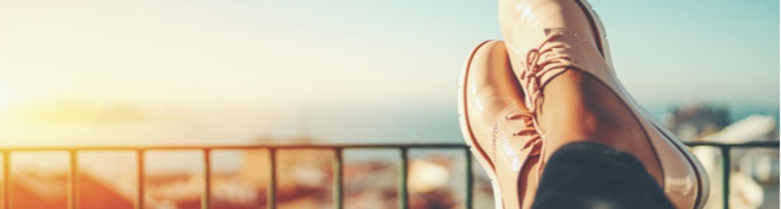 Close up of a woman sitting with their feet up on a balcony